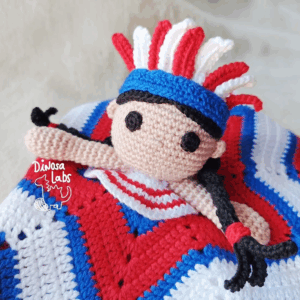Manta de apego hecha con crochet inspirada en un indio americano. Con colores azules, rojos y blancos